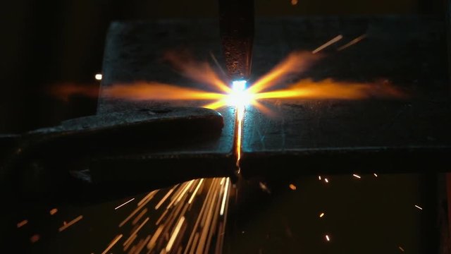 Oxyacetylene cutting through steel, gripping onto steel plate with tool