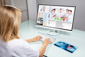 Dentist Video Conferencing With Her Colleagues On Computer