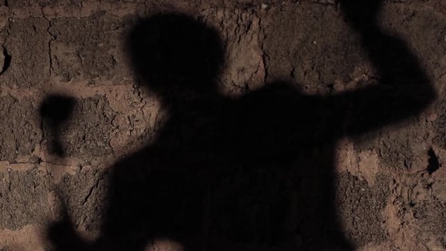 brick wall. silhouette of a singer singing with Elvis style microphone