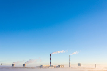 The cooling towers and pipes or tubes of thermal power station in the clear autumn sunny day