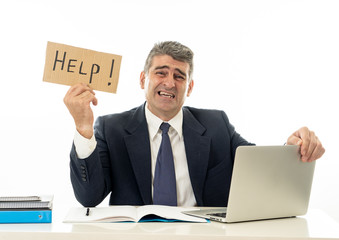 Depressed sad and frustrated middle aged businessman holding a help sign