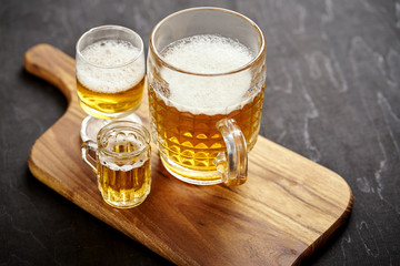 three golden delicious beers on an old black wooden table