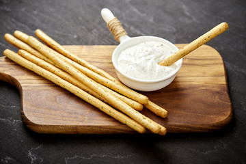 delicious salty sticks and garlic dip on an old black wooden table in a pub