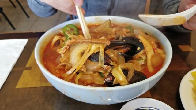 closeup of hands stirring up hot steamy noodles - 11 secs.
