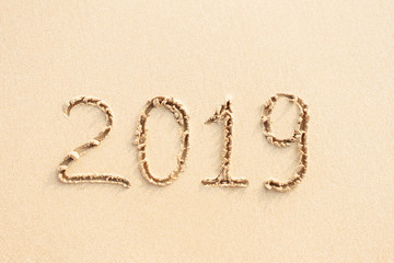 2019 handwritten on sandy tropical beach