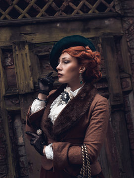 Beautiful woman face in the hat and red hair