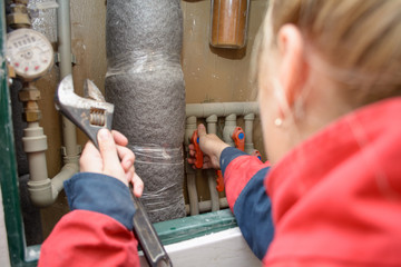 Hands of plumber using wrenches while repairing pipes, close up view. plumber worker with spanner installing water meter