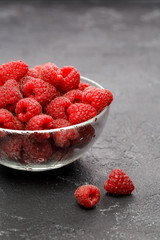 Photo of raspberries in transparent glass cup