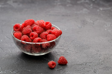 Photo of raspberries in transparent glass cup