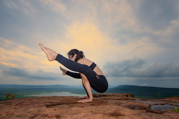 woman practice yoga training on the top peak of mountain, river and lake in background