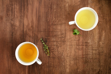An overhead photo of herbal tea on a dark wooden background, shot from above with a place for text