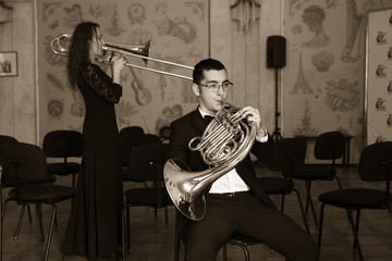 Two musicians playing on wind instruments