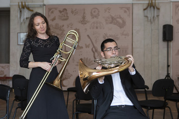 Two musicians playing on wind instruments
