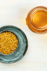 Healthy organic food. A top shot of bee pollen and a jar of honey on a light background with a place for text
