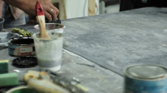 Masters in the art studio process the wood with paint and putty, achieve the aging effect