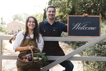 Farmers holding a blackboard welcoming sign