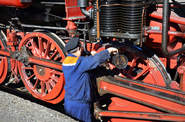 Popovo, Bulgaria, October 6 2018: Mechanic checks steam locomotive iin Popovo, Bulgaria