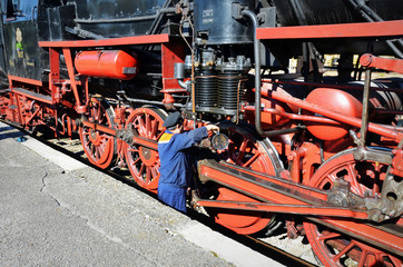 Popovo, Bulgaria, October 6 2018: Mechanic checks steam locomotive iin Popovo, Bulgaria