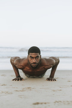 Fit man doing pushups in the sand