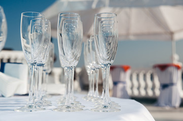 many empty wineglasses in rows at white table. welcome drink. catering