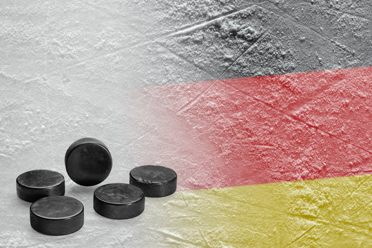 Hockey pucks and the image of the German flag on the ice