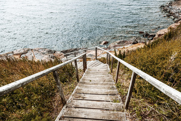 Obraz premium Wooden paths stairs along the coast on the island of Suomenlinna, a beautiful seascape. Islands of Finland