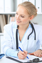 Doctor and patient in hospital. Little girl is being examined by pediatrician with stethoscope. Medicine and health care
