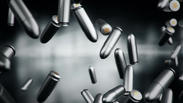 Animation falling of bullets different calibers on dark and blurred background. Animation of seamless loop.