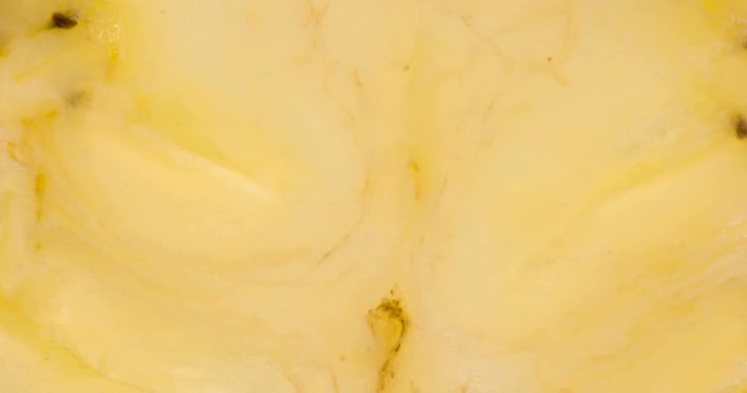 Two Banana Slices Under Pressure. The flesh of the banana is compressed and crushed close-up on a bright white background, creating a juicy splash of pulp and juice. Shooting at 120 fps