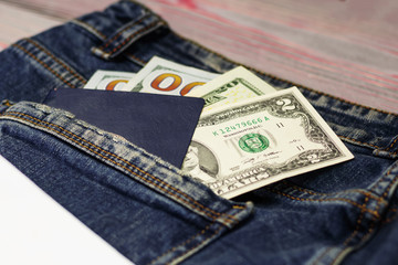 Blue jeans back pocket view - bank plastic card and passport. next to the pocket is a children's toy airplane.