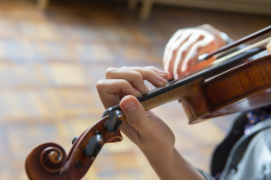 Hand on the strings of a violin