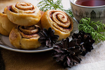 Cinnamon rolls buns with spices and tea. Kanelbulle - swedish sweet homemade dessert. Christmas baking pastry.
