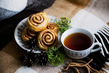 Cinnamon rolls buns with spices and tea. Kanelbulle - swedish sweet homemade dessert. Christmas baking pastry.