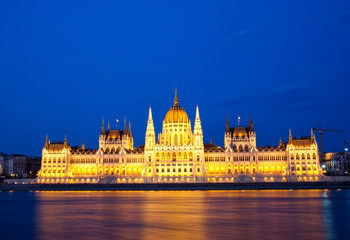 travel and european tourism concept. Budapest, Hungary. Hungarian Parliament Building over Danube River illuminated at night.