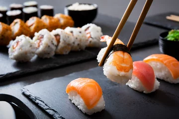 Foto op Plexiglas Picking up a sushi piece with chopsticks © Rido