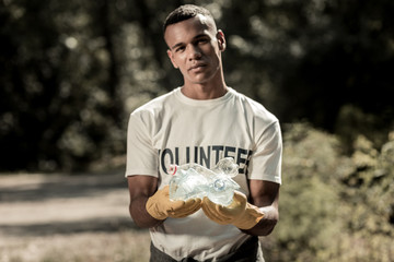 Active volunteer. Active volunteer wearing bright yellow gloves and white shirt with volunteer sign...
