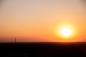 The colorful sunset in the big urbanized city from from the roof of a tall building
