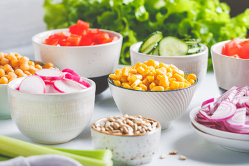 Assortment ingredients for healthy vegetarian salad in different portion bowls on a table. The concept of fitness and vegan food.