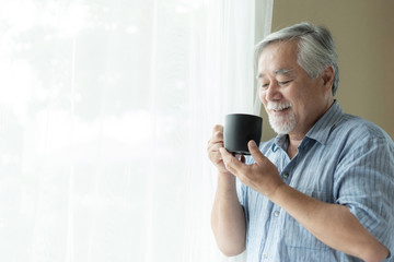 Senior male feel happy drinking coffee in the morning, enjoying time in his home indoor background - lifestyle senior happiness concept