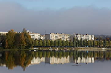 Naklejka premium Cityscape with white buildings and calm lake