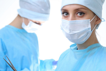 Surgeon doctor in mask performing operation. Focus on female intern girl. Medicine, emergency help...