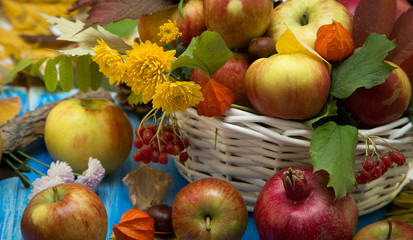 Naklejka na ściany i meble Autumn bright background. Flowers, leaves and fruits on a blue wooden background. Background for the autumn holidays and thanksgiving day.