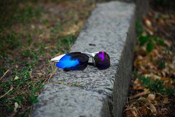 Blue sunglasses lying on the curb