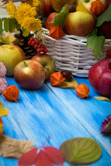 Autumn bright background. Flowers, leaves and fruits on a blue wooden background. Background for the autumn holidays and thanksgiving day.