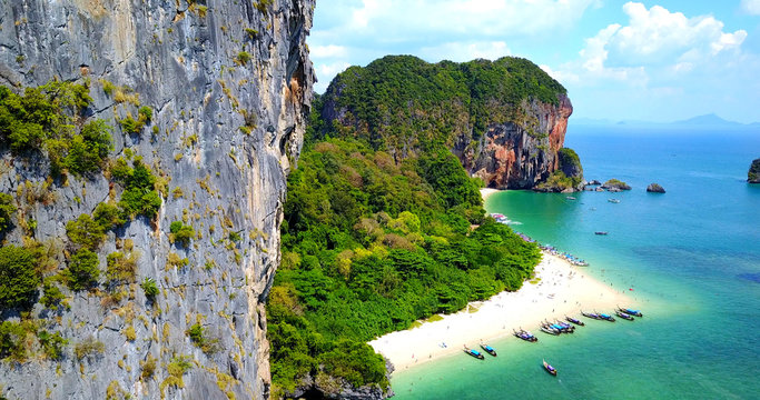 Aerial Overhead View of Boats on Tropical Island Beach Surrounded by Rocky Cliffs And Lush Greenery - Phra Nang Bay, Thailand