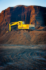 Excavator on a woodchips pile