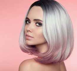 Girl Portrait of Ombre bob short hairstyle. Beautiful hair coloring woman. Trendy puprle haircut. Blond model with short shiny haircuts isolated on pink Background. Makeup. Beauty Salon.