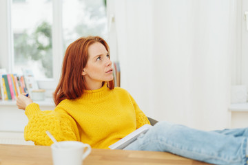 young woman sitting pondering a problem