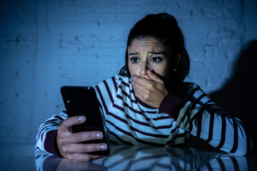 Worried unhappy young woman suffering from cyberbullying and harassment online by mobile phone