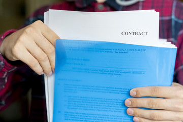 close up hands holding blue paper folder with documents, contract sheet f